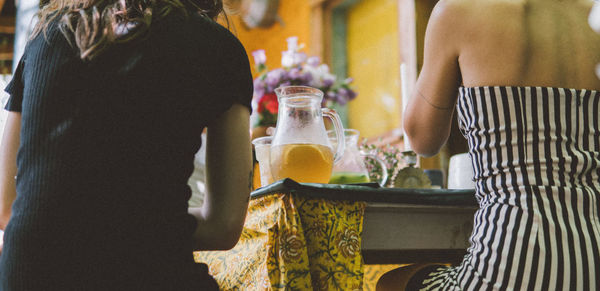 Rear view of woman holding glass bottle