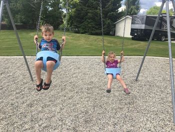 Full length of siblings playing in park