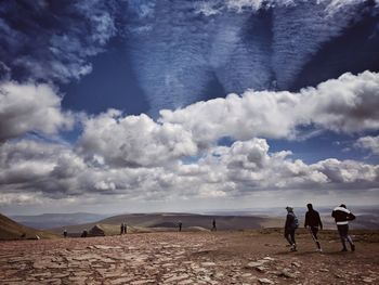 People at beach against sky