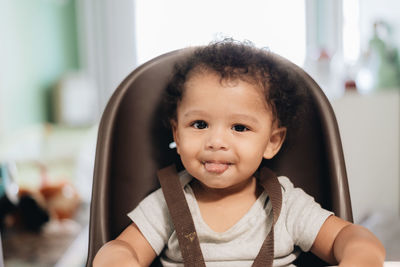 Portrait of cute smiling boy sitting at home