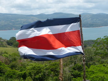 Scenic view of flag on mountain range against sky