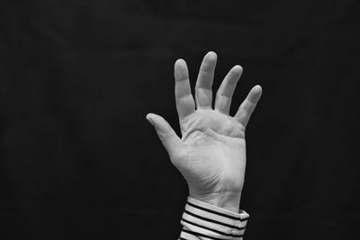 Close-up of person hand against black background