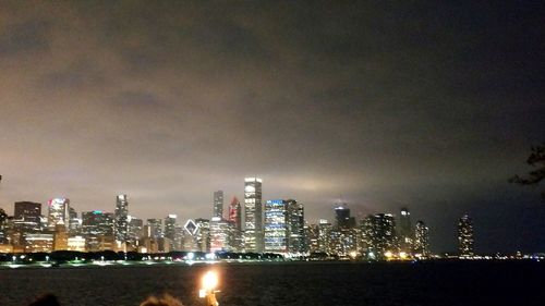 Illuminated buildings in city against sky at night