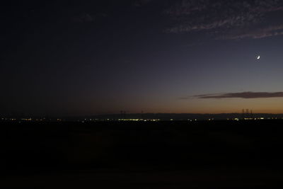 Illuminated city against sky at night