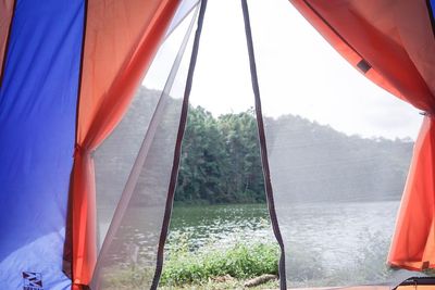 View of tent against sky seen through window