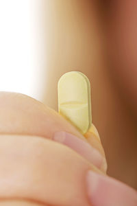 Close-up of hand holding pill 