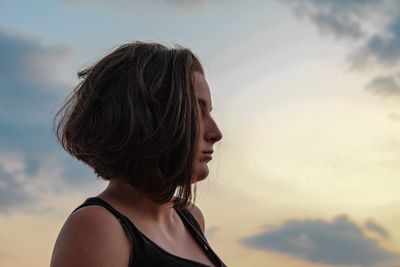 Close-up of young woman against sky