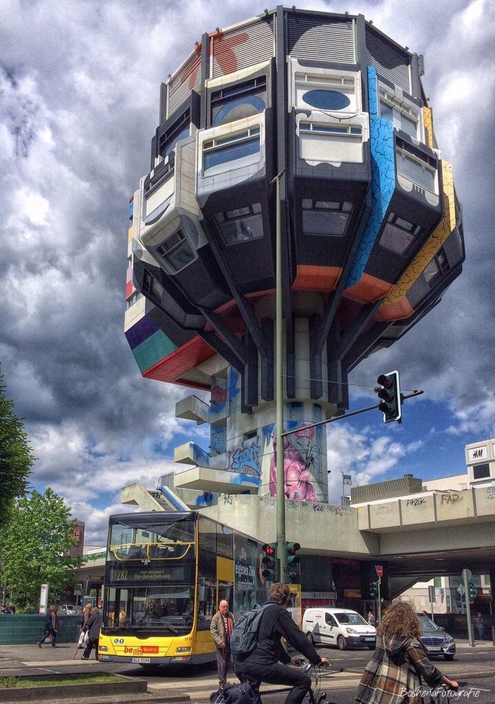 transportation, sky, land vehicle, cloud - sky, architecture, mode of transport, built structure, cloudy, car, building exterior, cloud, low angle view, street, road, city, incidental people, overcast, stationary, day, travel