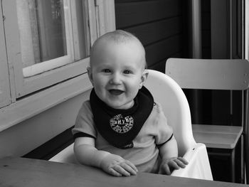 Portrait of cute baby boy sitting on high chair