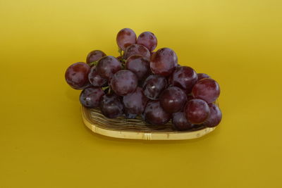 Directly above shot of grapes on yellow background