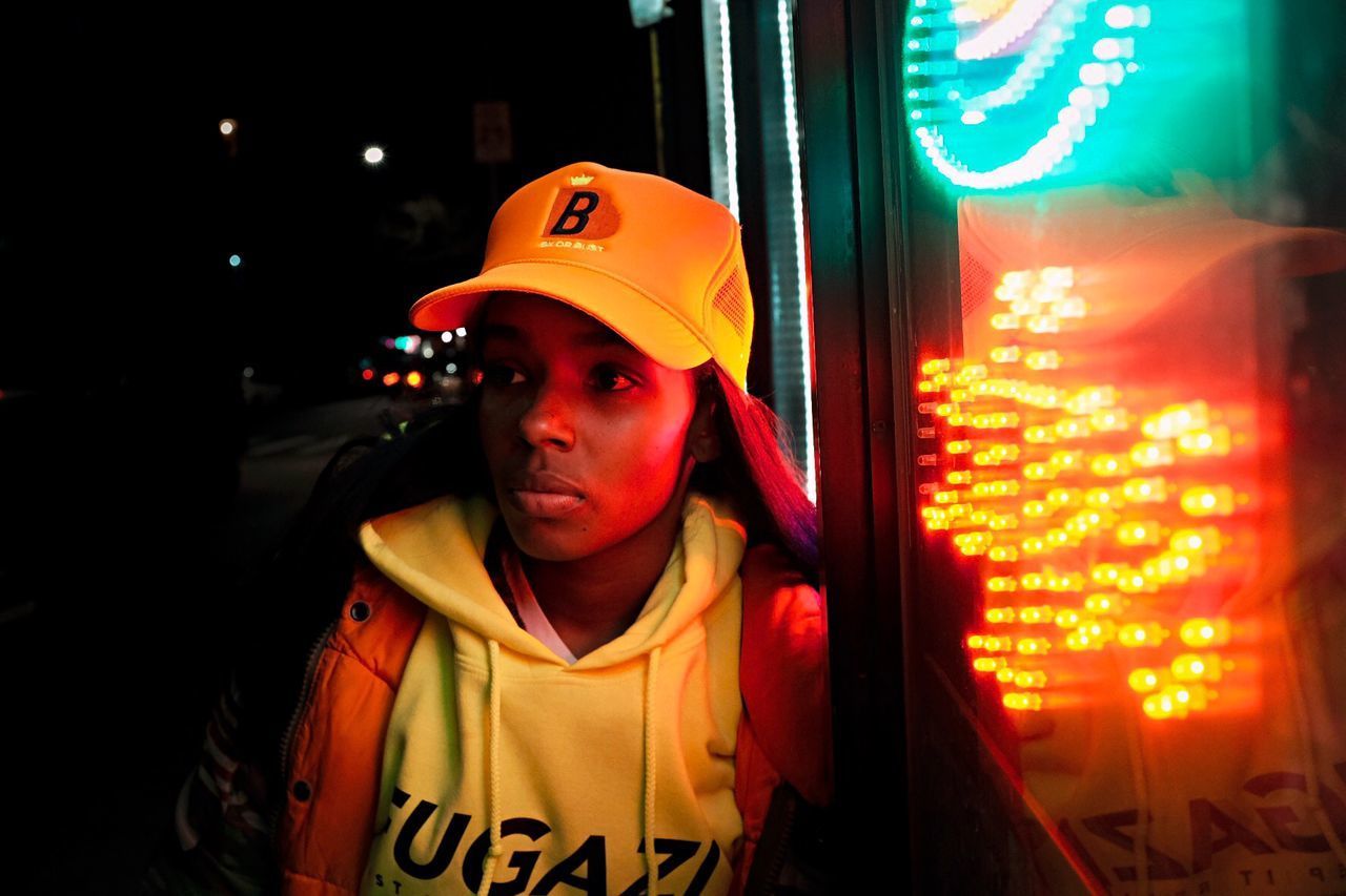 PORTRAIT OF WOMAN WEARING HAT AT NIGHT DURING FESTIVAL