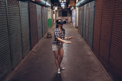 Full length of woman standing against wall