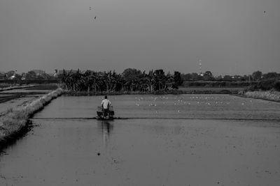 People working in farm against clear sky