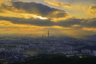 Aerial view of buildings against cloudy sky during sunset