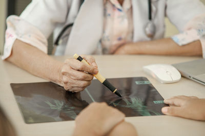 Midsection of man working on table