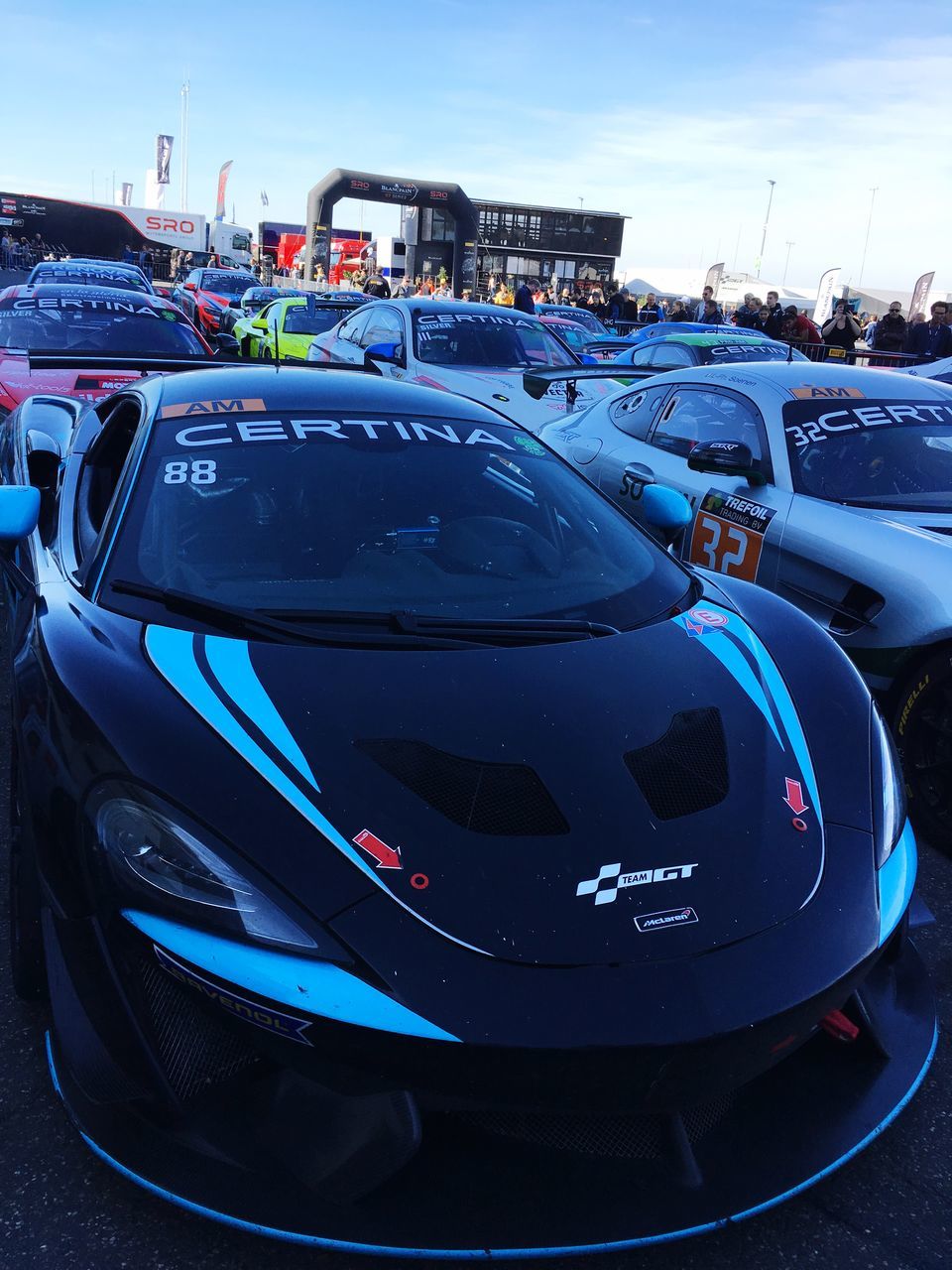 CLOSE-UP OF BLUE CAR ON ROAD AGAINST SKY