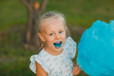 Cute girl eating cotton candy in park