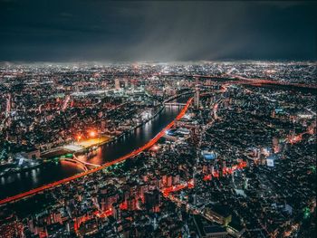 High angle view of illuminated city against sky at night