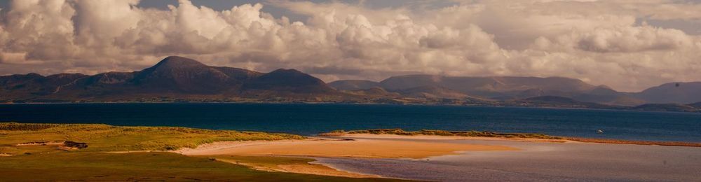 Panoramic view of sea and mountains against sky