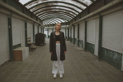 Full length portrait of woman standing on tiled floor