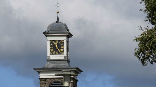 Low angle view of cross on building against sky