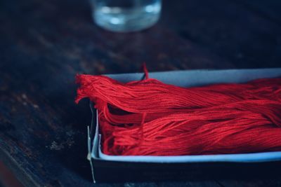 Close-up of red wool in box on table