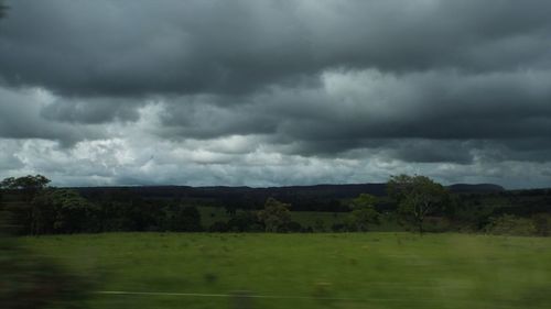Scenic view of field against cloudy sky
