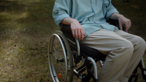 Midsection of man riding bicycle on field