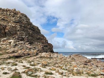 Rock formation on beach against sky