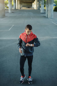 Man checking time while standing on street