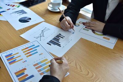 Midsection of business colleagues working on table