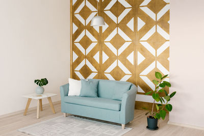 Living room in the scandinavian style. geometric carved panel on the wall and blue sofa in the house