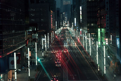 Traffic on city street by buildings at night