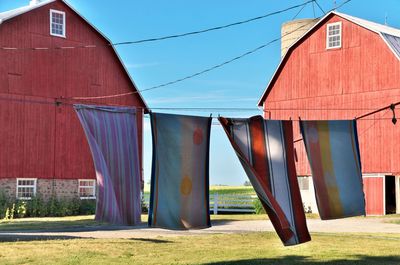 Towels drying on a clothesline at a rural farm in ontario with red barns in background. 