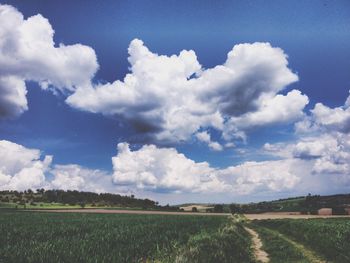 Scenic view of field against cloudy sky