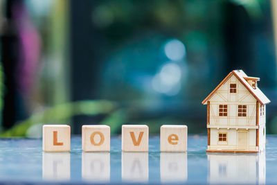 Close-up of block shape with letter and model house on table