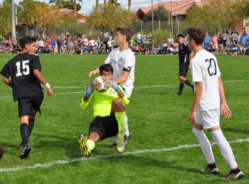 Men playing soccer on field