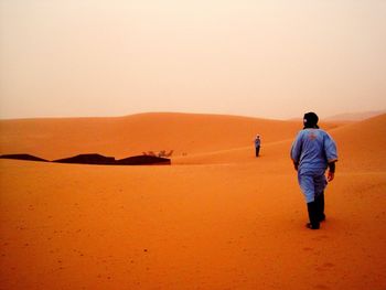 Man standing on sand dune in desert