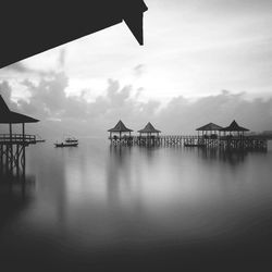 Pier on sea against cloudy sky