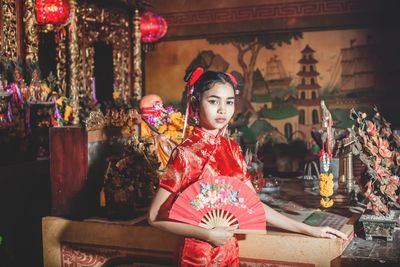 Portrait of young woman sitting in traditional clothing