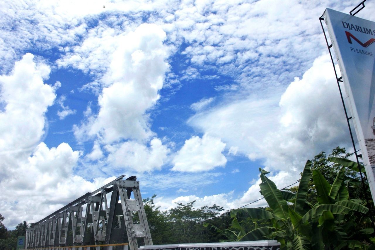 sky, cloud - sky, mountain, cloudy, cloud, low angle view, text, built structure, mountain range, nature, architecture, day, tree, outdoors, beauty in nature, western script, no people, transportation, building exterior, scenics