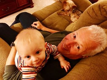 High angle portrait of grandfather with cute grandson at home