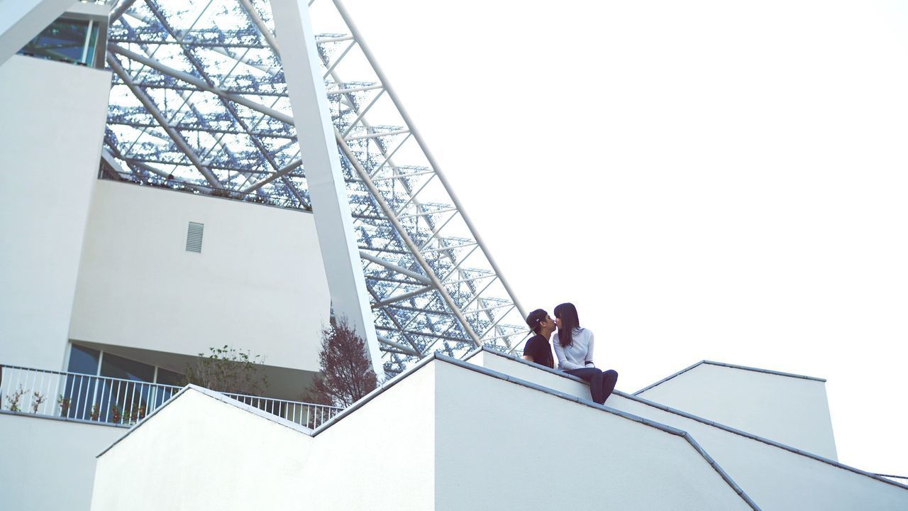 LOW ANGLE VIEW OF PEOPLE ON STAIRCASE AGAINST SKY