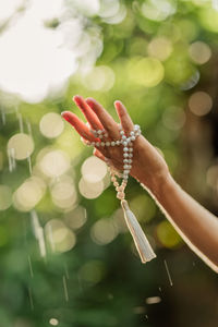 Cropped hand of woman catches drops of water