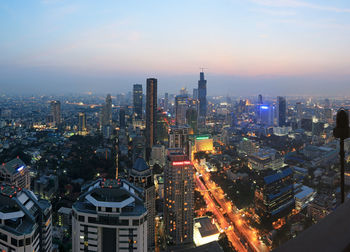 Illuminated cityscape against sky at night