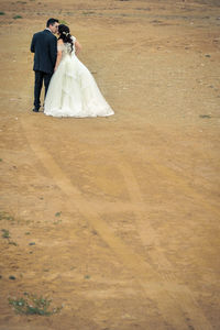 Rear view of couple standing on footpath