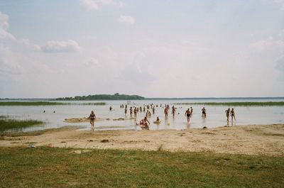 People at beach against sky
