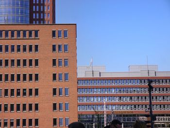 Low angle view of office building against blue sky