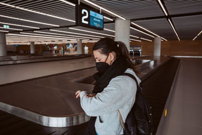 Side view of young woman standing in subway