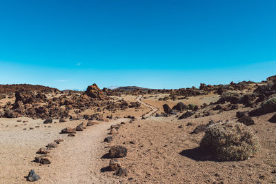 Scenic view of arid landscape against clear blue sky